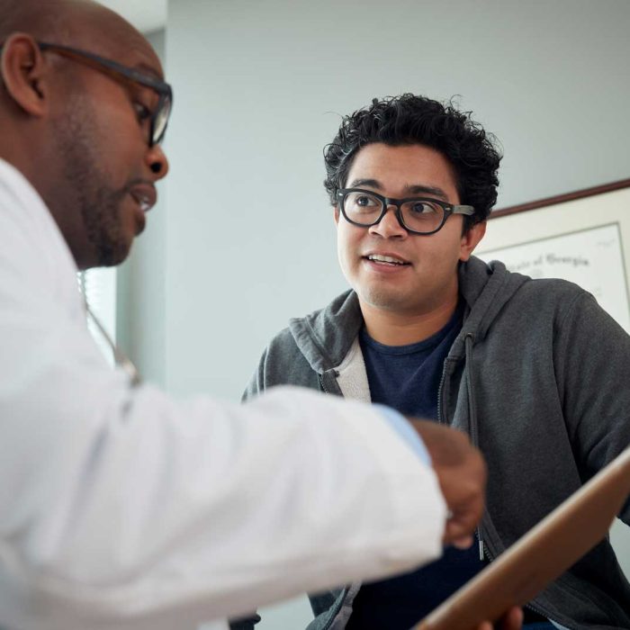 Doctor talking to boy in examination room Doctor talking to boy in examination room